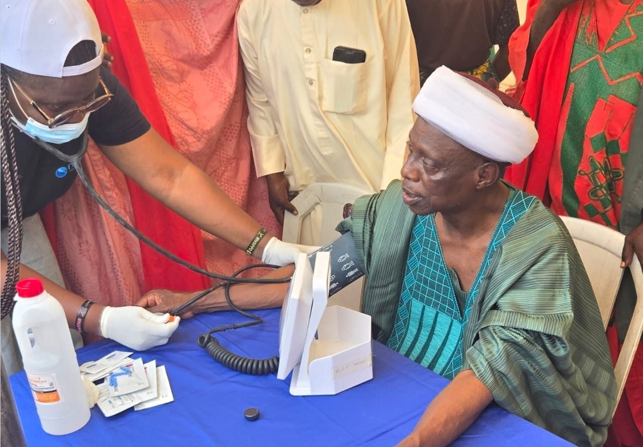 A health worker checks a community elder's blood pressure during the outreach