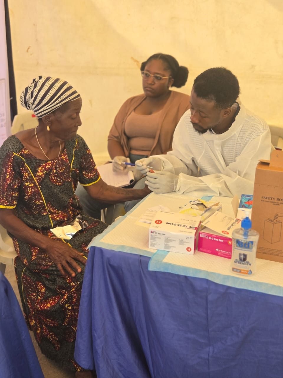 A resident receives a free hepatitis test from a health worker at the testing table