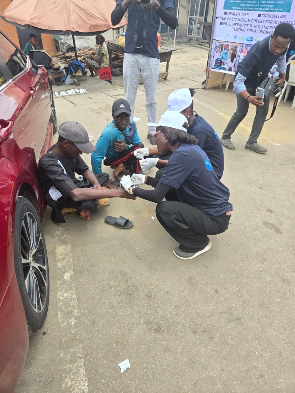 Outreach volunteers screening residents on the street outside the palace grounds