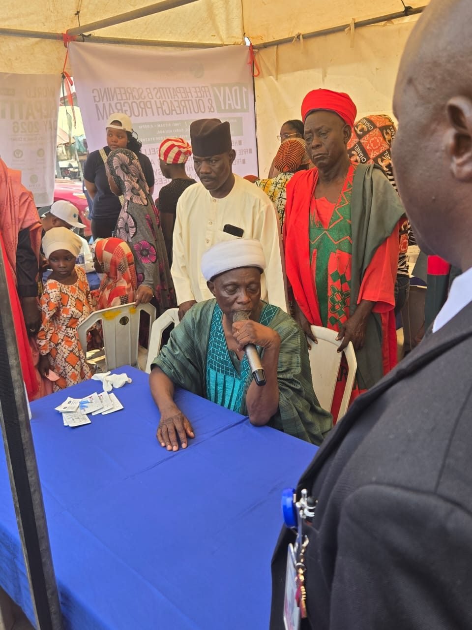 Traditional leaders and community members seated under the tent at the outreach
